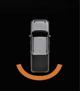 2026 기아 타스만 후방 주차 거리 경고 인포테인먼트 시스템 화면 이미지입니다. 차량 평면도 뒤쪽에 주황색 곡선 형태의 경고 라인이 표시되어 있습니다. 후방 물체와의 거리가 30~60cm 범위일 때 인포테인먼트 시스템에 나타나는 시각적 경고 표시를 설명합니다.