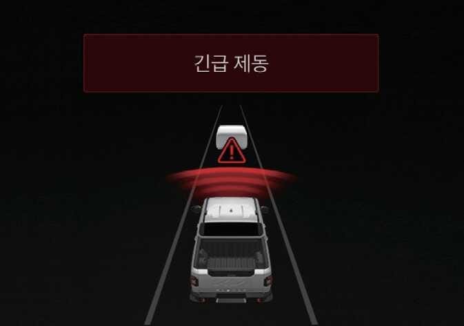 2026 기아 타스만 전방 충돌방지 보조의 긴급 제동 이미지입니다. 상단에 '긴급 제동' 문구가 붉은색 박스에 표시되고, 전방 차량과의 사이에 붉은색 삼각형 느낌표 아이콘과 레이더 파동이 나타나 있습니다. 충돌 위험 시 경고하고 제동을 제어하여 충돌 회피를 돕는 기능을 설명합니다.