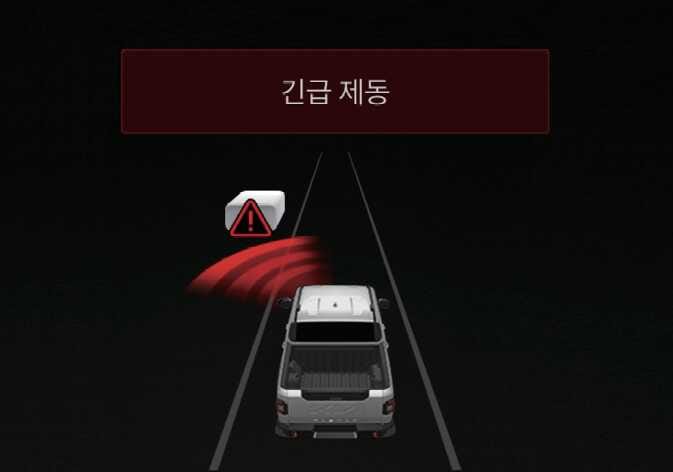 2026 기아 타스만 전방 충돌방지 보조 시스템의 긴급 제동 이미지입니다. 차량 전방에서 붉은색 감지 신호가 맞은편 대향차를 향해 표시되고, 대향차 위에 붉은색 삼각형 느낌표 경고 아이콘이 떠 있습니다. 상단에는 '긴급 제동' 문구가 표시됩니다. 교차로 대향차와의 충돌 위험 시 긴급 제동하는 기능을 설명합니다.