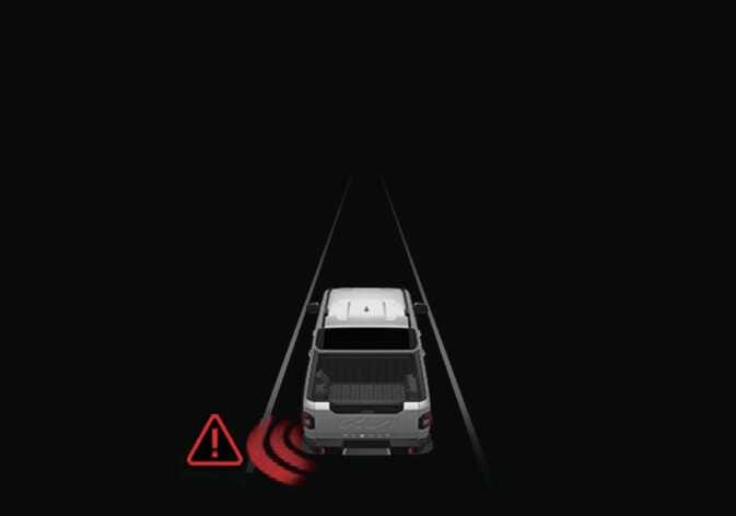 2026 기아 타스만 측방 접근차 대응 충돌 경고 이미지입니다. 어두운 도로 위 차량의 좌측 후방에서 붉은색 레이더 파동이 퍼져 나가고, 그 옆에 붉은색 삼각형 느낌표 경고 아이콘이 표시되어 있습니다. 측방에서 접근하는 차량을 감지하여 운전자에게 충돌 위험을 경고하는 기능을 설명합니다.