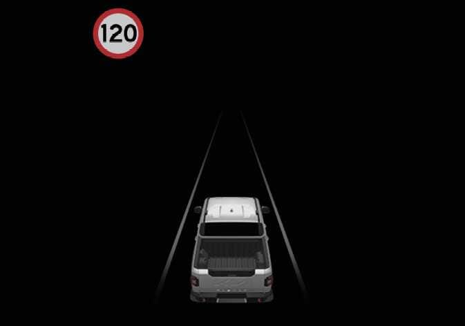 2026 기아 타스만 지능형 속도 제한 보조 이미지입니다. 어두운 배경의 도로 위를 주행하는 차량 좌측 상단에 빨간색 테두리의 원형 표지판과 숫자 120이 표시되어 있습니다. 클러스터에 도로의 제한 속도 정보를 표시하는 기능을 설명합니다.