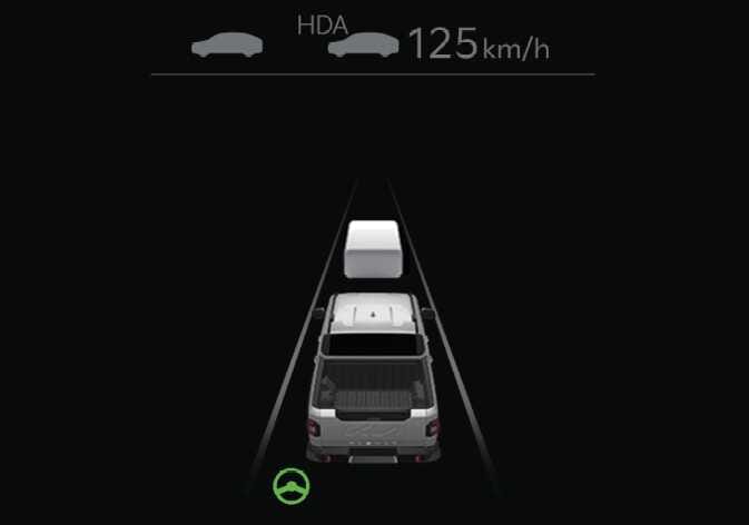 2026 기아 타스만 고속도로 주행 보조 대기 상태 이미지입니다. 계기판 상단에 HDA 문구와 차량 아이콘, 설정 속도 125km/h가 회색으로 표시되어 있습니다. 화면 중앙에는 주행 차량과 전방 차량, 차선이 그래픽으로 나타나며 하단에는 초록색 스티어링 휠 아이콘이 점등되어 있습니다. 고속도로 주행 보조 기능이 대기 상태일 때 계기판에 표시되는 화면 구성을 설명합니다.