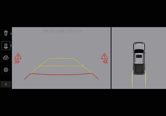2026 기아 타스만 인포테인먼트 시스템의 후방 교차 충돌 경고 화면 이미지입니다. 후방 카메라 영상 좌우측에 붉은색 삼각형 느낌표 아이콘과 화살표가 표시되어 접근하는 차량의 방향을 알립니다. 후방 교차 충돌 위험 시 화면에 경고를 표시하여 운전자가 상황을 인지하도록 돕는 기능을 설명합니다.