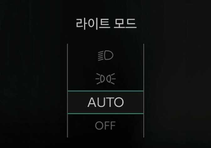 2026 기아 타스만 라이트 모드 설정 화면 이미지입니다. 검은색 배경의 화면 상단에 '라이트 모드' 문구가 있고, 아래로 전조등, 미등 아이콘과 'AUTO', 'OFF' 텍스트가 수직으로 나열되어 있습니다. 현재 'AUTO' 항목이 청록색 테두리 박스로 강조되어 선택된 상태를 보여줍니다. 조명 스위치 조작 시 LCD 표시창에 나타나는 라이트 모드 변경 상태를 설명합니다.