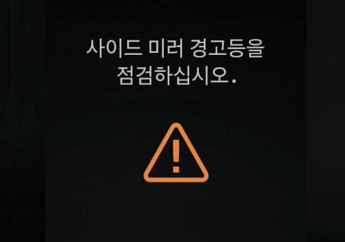 2026 기아 타스만 사이드 미러 경고등 점검 경고문 이미지입니다. 검은색 클러스터 화면 중앙에 '사이드 미러 경고등을 점검하십시오.'라는 안내 문구가 표시되어 있고, 하단에는 주황색 삼각형 안에 느낌표가 그려진 통합 경고등 아이콘이 위치해 있습니다. 실외 미러 경고등 시스템에 기능 이상이 감지되었을 때 운전자에게 상황을 알리고 점검을 유도하는 화면 구성을 설명합니다.