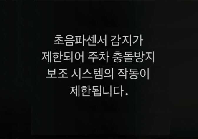 2026 기아 타스만 후방 초음파센서 가림 경고 화면 이미지입니다. 검은색 배경의 화면 중앙에 '초음파센서 감지가 제한되어 주차 충돌방지 보조 시스템의 작동이 제한됩니다.'라는 흰색 문구가 표시되어 있습니다. 초음파센서 주변 오염이나 가림으로 인해 시스템 작동이 제한됨을 알리는 기능을 설명합니다.