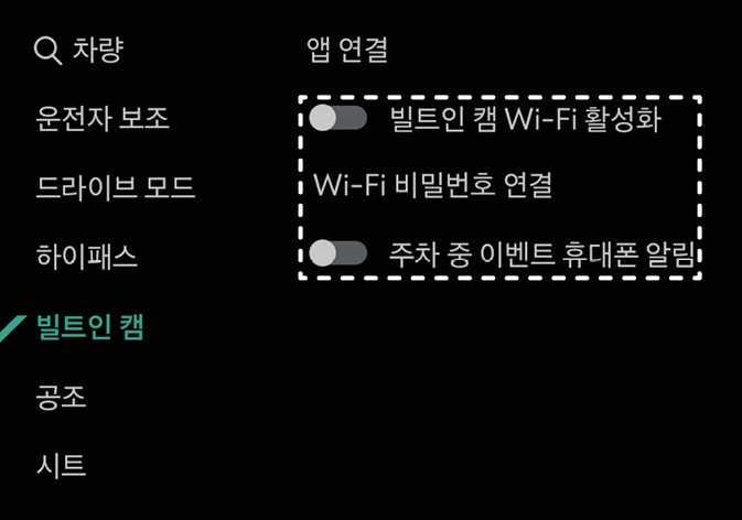2026 기아 타스만 빌트인 캠 앱 연결 설정 화면 이미지입니다. 인포테인먼트 시스템 설정 메뉴 중 '빌트인 캠'이 청록색으로 강조되어 선택된 상태입니다. 오른쪽 화면에는 '빌트인 캠 Wi-Fi 활성화', 'Wi-Fi 비밀번호 연결', '주차 중 이벤트 휴대폰 알림' 항목이 표시되어 있으며, 해당 항목들이 흰색 점선 박스로 강조되어 있습니다. 스마트폰 앱과 연결하기 위해 Wi-Fi 및 알림 설정을 활성화하는 기능을 설명합니다.