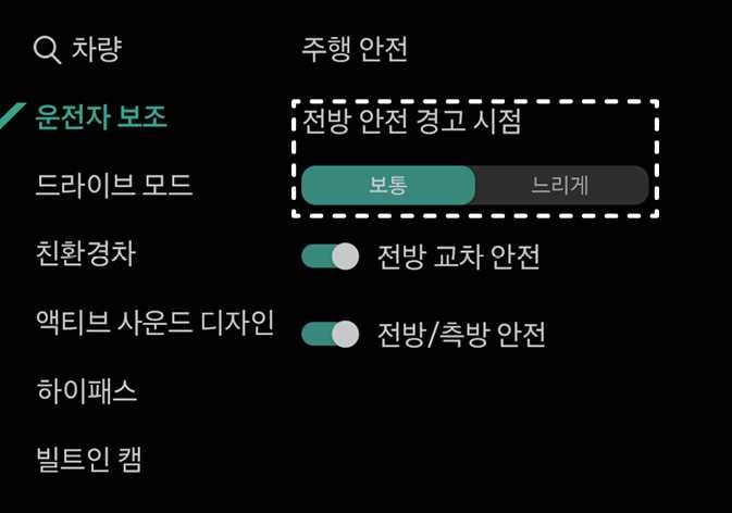 2026 기아 타스만 전방 안전 경고 시점 설정 화면 이미지입니다. 운전자 보조 메뉴의 주행 안전 항목에서 '전방 안전 경고 시점'이 점선 박스로 강조되어 있습니다. 옵션 중 '보통' 버튼이 청록색으로 선택되어 있고, 우측에 '느리게' 버튼이 배치되어 있습니다. 전방 충돌방지 보조 시스템의 경고 알림 시점을 사용자가 선택하여 설정하는 기능을 설명합니다.