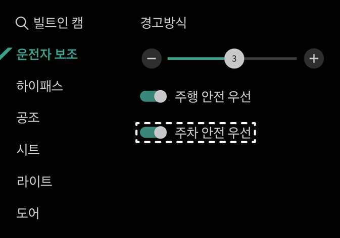 2026 기아 타스만 인포테인먼트 시스템의 경고 방식 설정 화면 이미지입니다. 좌측 메뉴의 '운전자 보조'가 선택되어 있고, 우측 목록에서 '주차 안전 우선' 항목의 토글 스위치가 흰색 점선 박스로 강조되어 있습니다. 주차 시 안전을 위해 오디오 음량을 줄이는 기능을 활성화하는 화면 구성을 설명합니다.