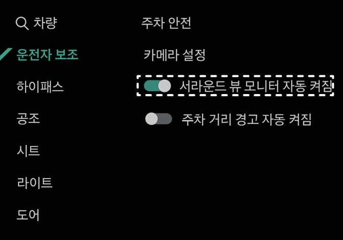 2026 기아 타스만 인포테인먼트 시스템의 운전자 보조 설정 화면 이미지입니다. 좌측의 '운전자 보조' 메뉴가 선택된 상태에서 우측 '주차 안전' 항목 내 '서라운드 뷰 모니터 자동 켜짐'이 흰색 점선 박스로 강조되어 있습니다. 해당 기능의 토글 스위치가 켜짐 상태로 설정되어 있어, 주차 거리 경고 발생 시 서라운드 뷰 모니터가 자동으로 작동하도록 설정하는 기능을 설명합니다.