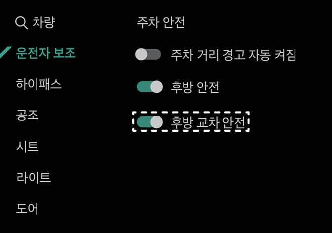 2026 기아 타스만 후방 교차 안전 설정 화면 이미지입니다. 인포테인먼트 시스템의 '차량' 메뉴 내 '운전자 보조' 탭에서 '주차 안전' 항목이 표시됩니다. 목록 중 '후방 교차 안전'의 토글 버튼이 켜짐 상태로 설정되어 있으며, 흰색 점선 박스로 강조되어 있습니다. 설정 메뉴에서 후방 교차 충돌방지 보조 기능을 활성화하는 화면 구성을 설명합니다.