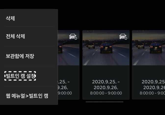 2026 기아 타스만 빌트인 캠 설정 메뉴 화면 이미지입니다. 인포테인먼트 시스템 화면 좌측 메뉴 목록 중 '빌트인 캠 설정' 항목이 흰색 점선 박스로 강조되어 있습니다. 메뉴 위쪽에는 '삭제', '전체 삭제', '보관함에 저장' 항목이 표시되어 있고, 우측에는 녹화된 주행 영상 썸네일들이 나열되어 있습니다. 빌트인 캠 설정 메뉴에 진입하여 녹화 및 작동 관련 항목을 설정하는 기능을 설명합니다.